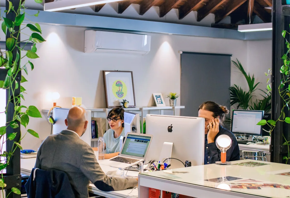 Team members working at their desks, one answering a phone call