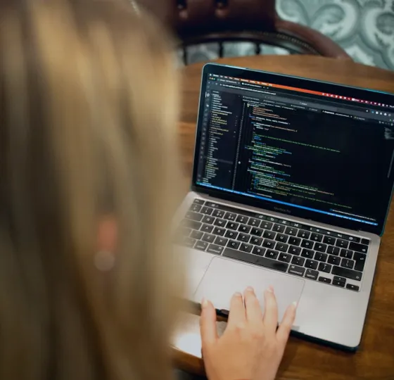 A developer writing code on a laptop
