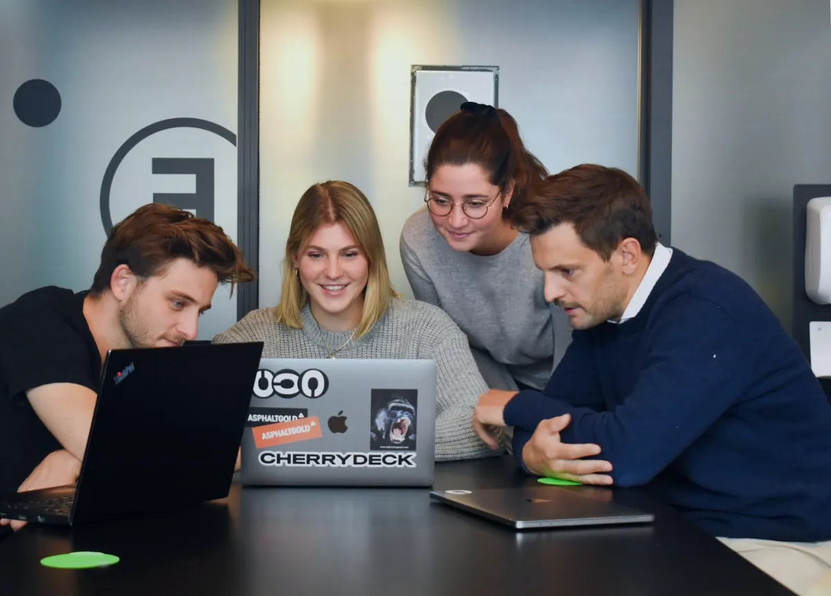 A small web team reviewing a site together on their laptops